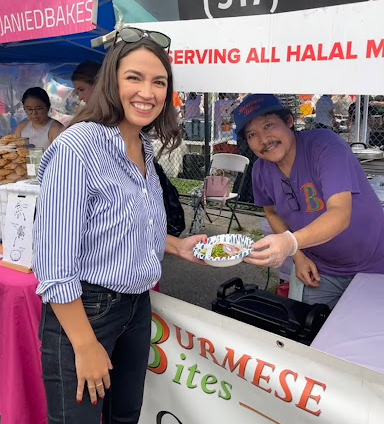 Rep. AOC smiles with a local vendor at the Queens Night Market